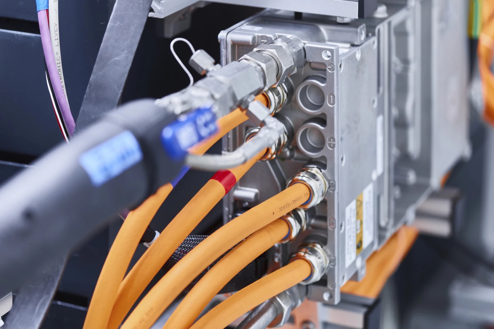 Orangefarbene Hochvolt-Kabel an einem Leistungselektronik-Prüfstand – Elektrifizierungs-Testing bei PID